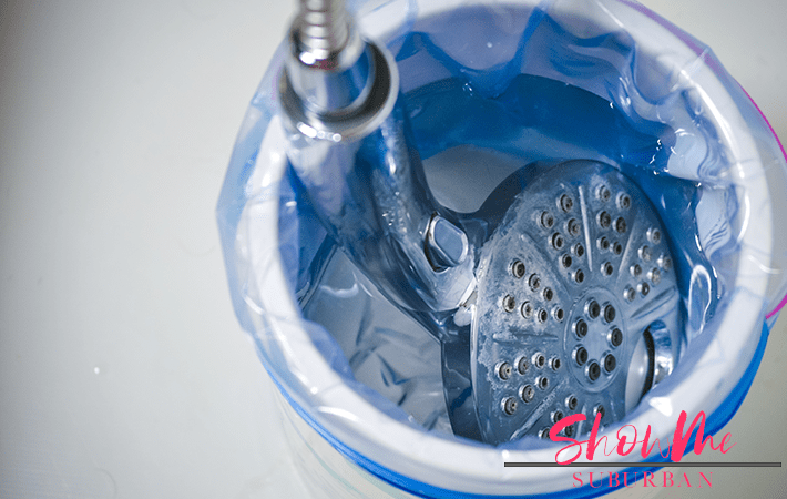 Shower head with text overlay | Gross shower head? You're not alone! Here's how to clean a dirty shower head. Easily remove bacteria, mildew, and lime scale using natural ingredients you probably already have at home! #cleaning