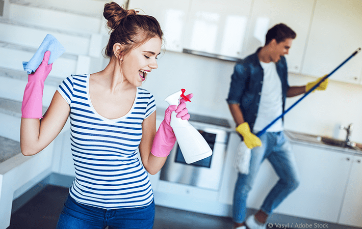 Man and woman dancing with cleaning supplies | Do you hate cleaning? There are ways to have fun while cleaning your house! Check out these 13 easy tips and ideas for how to make cleaning fun. Great for kids, families, and teens, too!