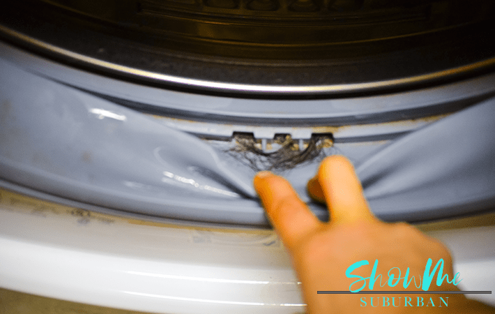 Washing machine with text overlay | Keeping your rubber washing machine gasket free of mold and mildew is an important part of home maintenance, and it's surprisingly quick and easy! These 3 simple steps to remove mold from a front-load washing machine seal are exactly what you need!